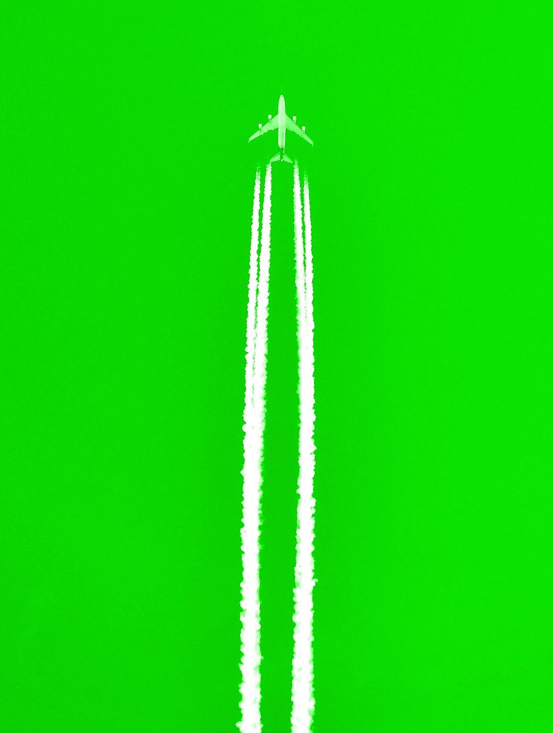 Aircraft with condensation stripes on green background